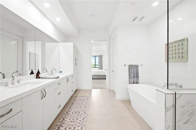 a large bathroom with a double vanity sink a mirror and a bathtub