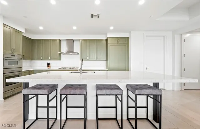 a kitchen with stainless steel appliances granite countertop a table and chairs in it