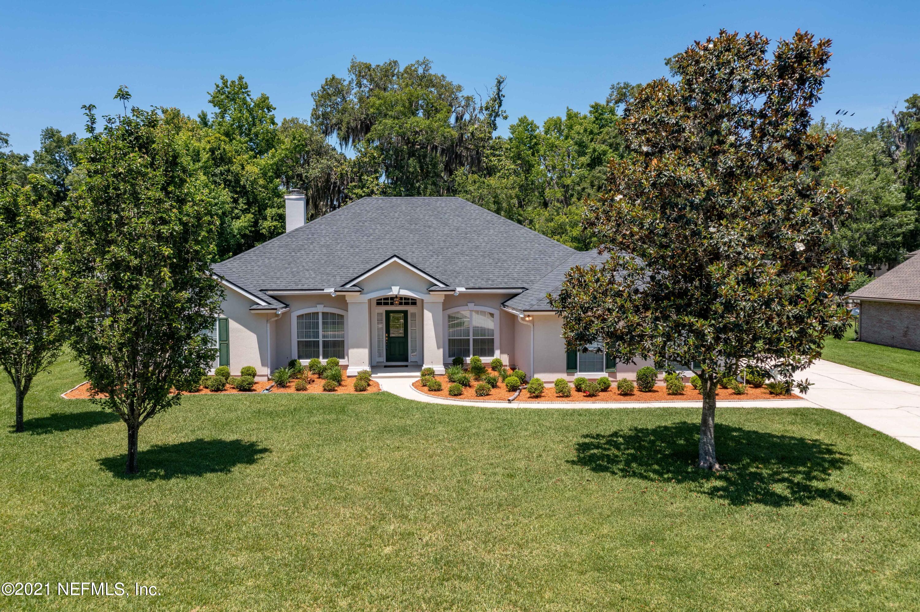 2284 Emilys Way Fleming Island, FL 32003 - Photo 1 of 52 a front view of a house with a yard table and chairs
