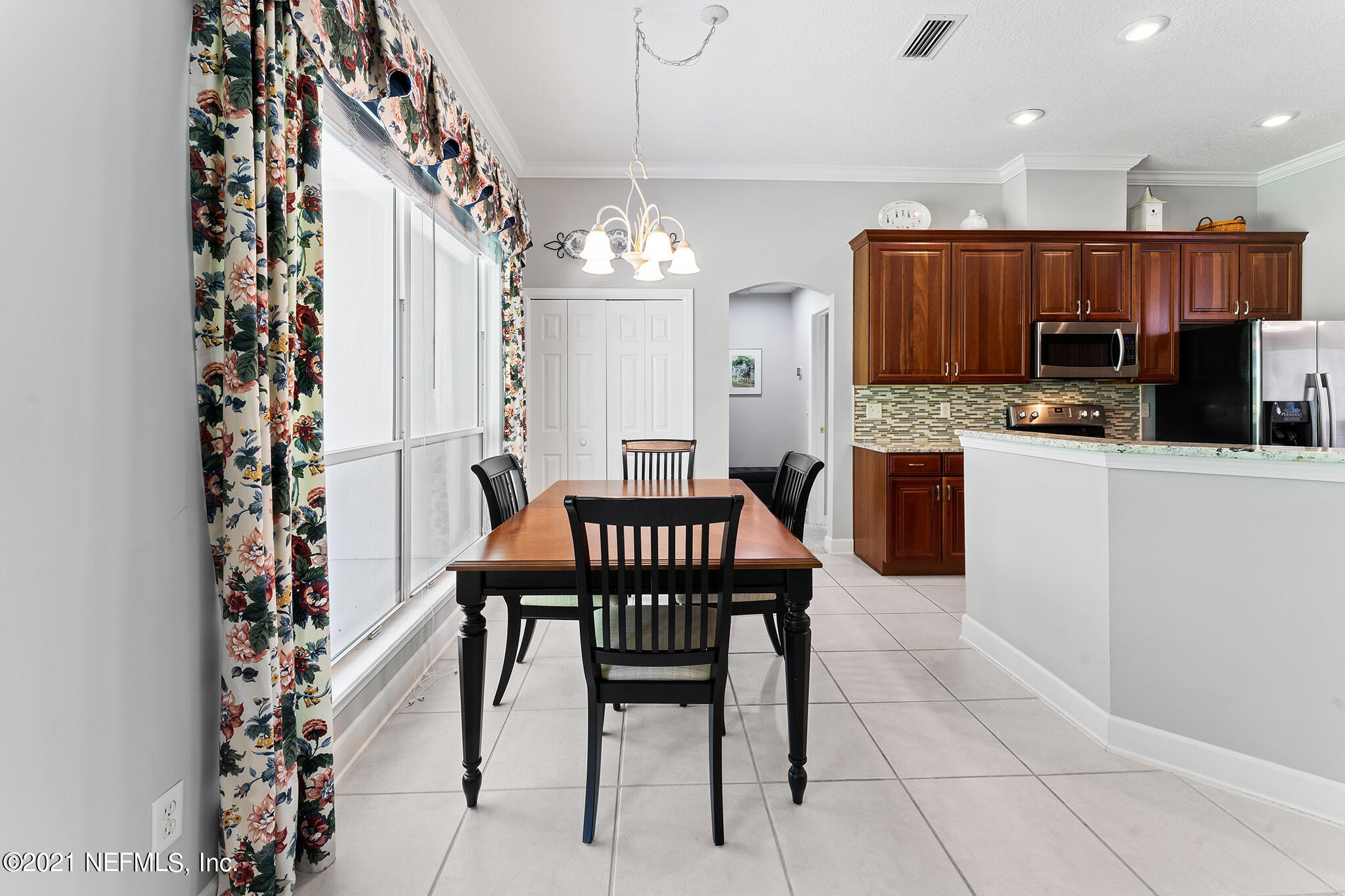2284 Emilys Way Fleming Island, FL 32003 - Photo 24 of 52 a kitchen with stainless steel appliances kitchen island granite countertop a dining table chairs and a refrigerator
