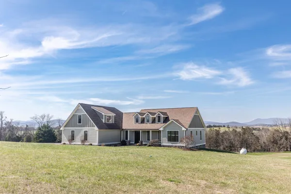a view of an empty room with wooden floor fireplace and a window