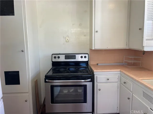 a kitchen with a stove and white cabinets