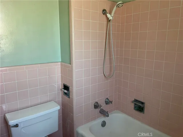 a bathroom with a shower a toilet and a bathtub