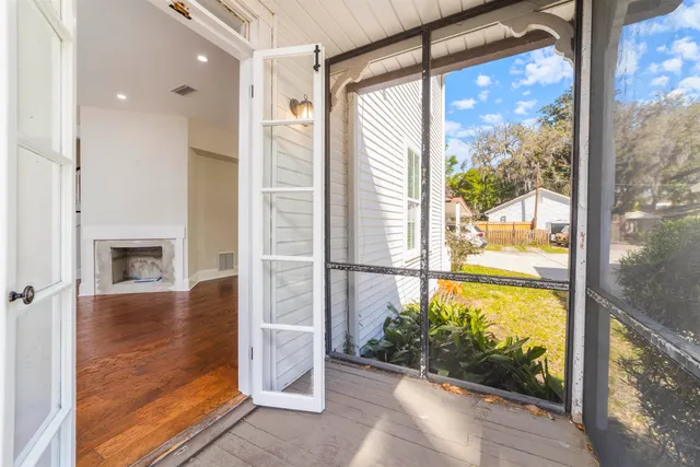 a view of a hallway with wooden floor staircase and a living room