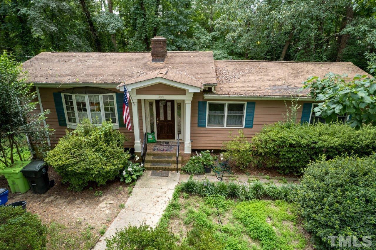 300 Dartmouth Road Raleigh, NC 27609 - Photo 19 of 52 a view of a white house with potted plants and a table and chairs
