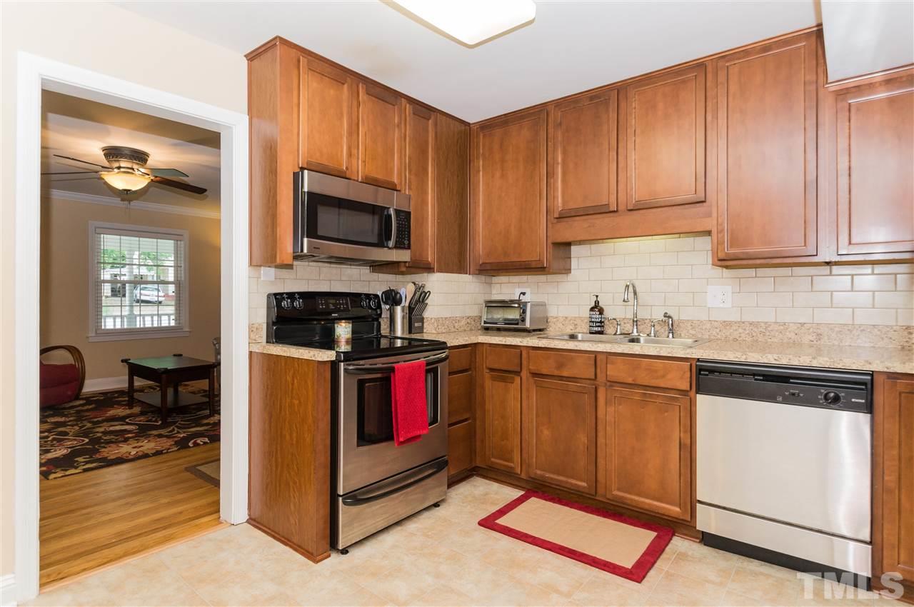 2132 Milburnie Road Raleigh, NC 27610 - Photo 9 of 23 a kitchen with granite countertop wooden cabinets a sink and dishwasher