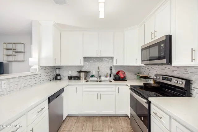 a kitchen with stainless steel appliances granite countertop a sink stove top oven and cabinets