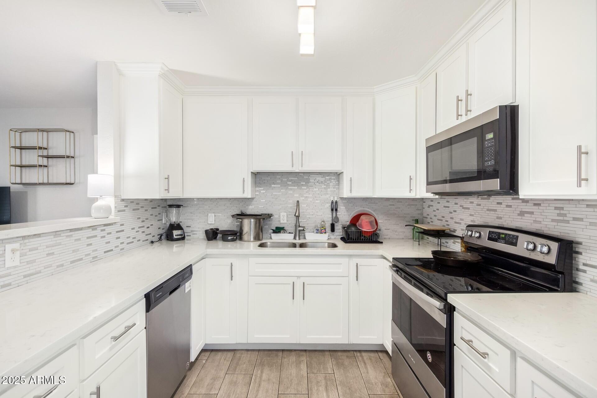 1619 West Peoria Avenue, Unit 2 Phoenix, AZ 85029 - Photo 4 of 8 a kitchen with stainless steel appliances granite countertop a sink stove top oven and cabinets
