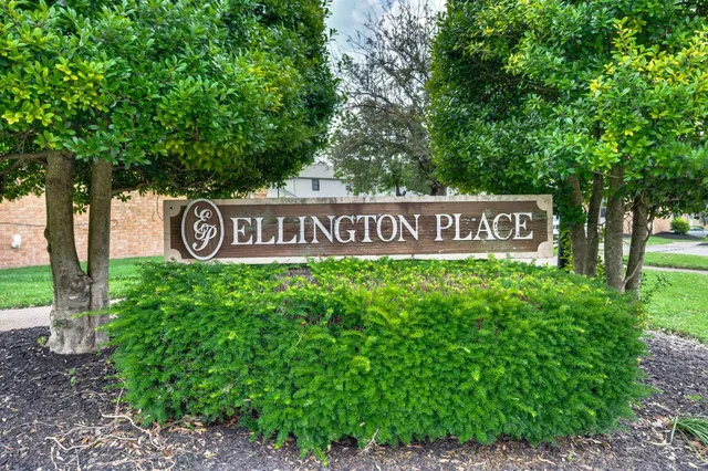 a sign that is sitting in front of a tree