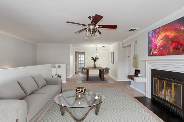 a living room with furniture a fireplace and a chandelier