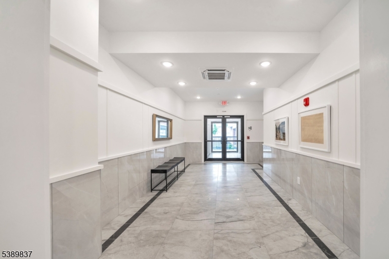 70 Ridgedale Avenue, Unit 102 Morristown, NJ 07960 - Photo 17 of 18 a view of a hallway with wooden floor and a living room