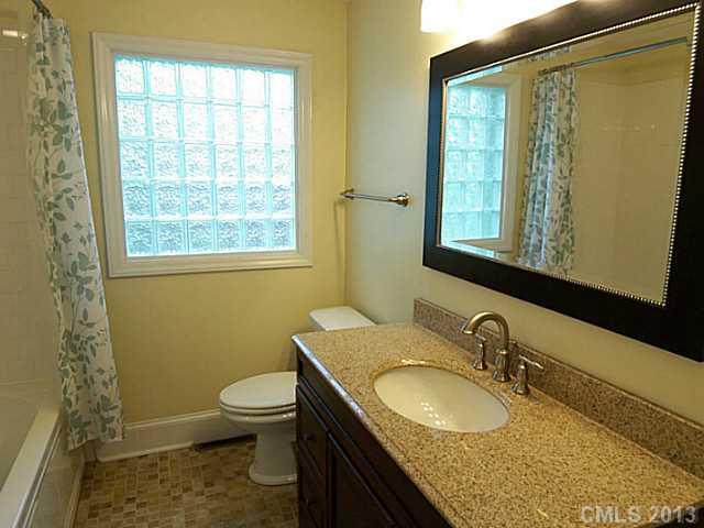 1943 Townsend Avenue Charlotte, NC 28205 - Photo 12 of 16 a bathroom with a granite countertop sink toilet and mirror