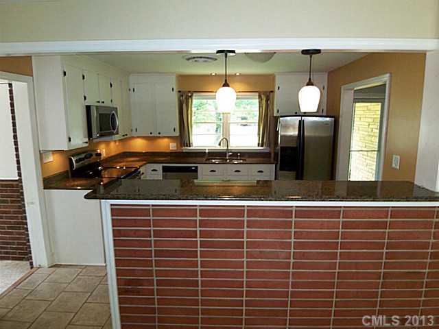 1943 Townsend Avenue Charlotte, NC 28205 - Photo 5 of 16 a bathroom with a granite countertop sink a window and a mirror