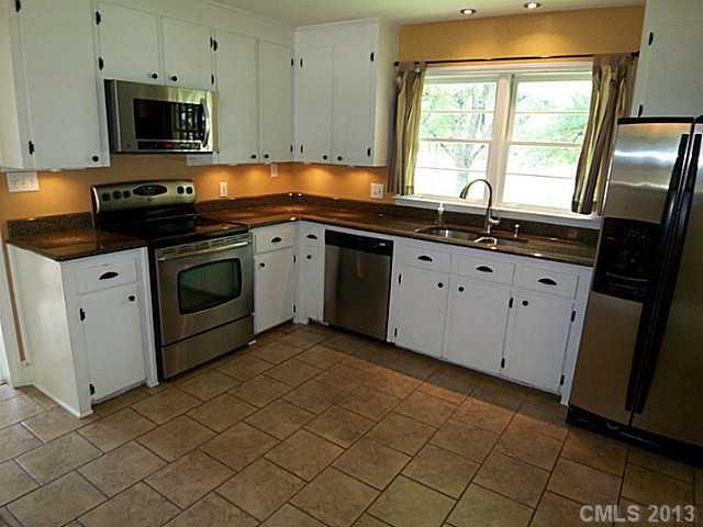 1943 Townsend Avenue Charlotte, NC 28205 - Photo 7 of 16 a kitchen with granite countertop white cabinets sink and a stove