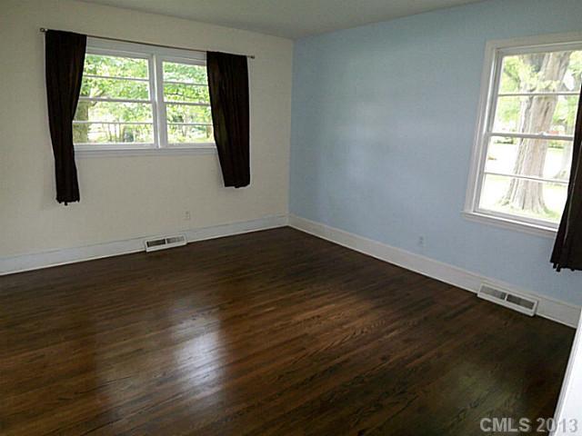 1943 Townsend Avenue Charlotte, NC 28205 - Photo 8 of 16 an empty room with wooden floor and windows