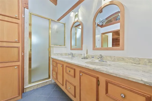 a bathroom with a granite countertop double vanity and a mirror