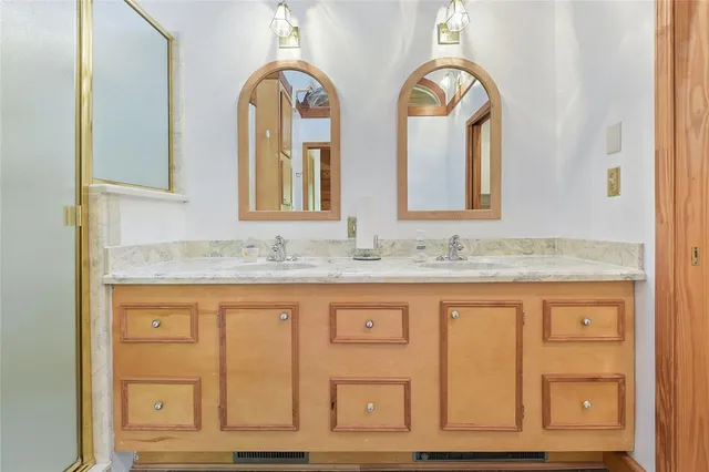 a bathroom with a granite countertop double vanity sink and a mirror