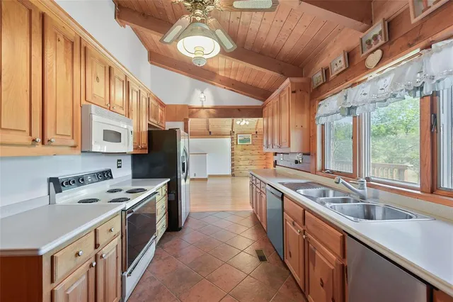 a kitchen with stainless steel appliances granite countertop a sink a stove and a refrigerator