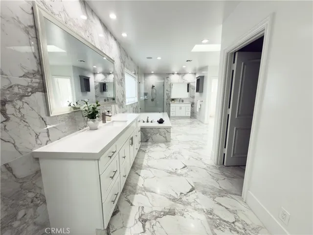 a bathroom with a tub sink shower and mirror