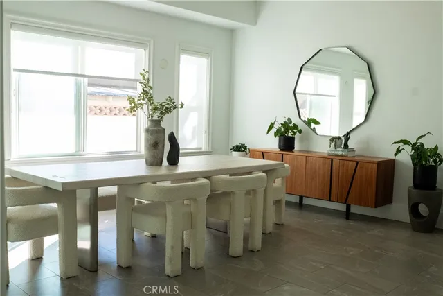 a room with a table chairs and a mirror