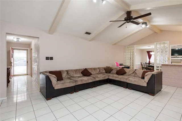a living room with furniture and a ceiling fan