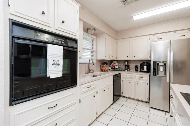 a kitchen with white cabinets appliances and sink