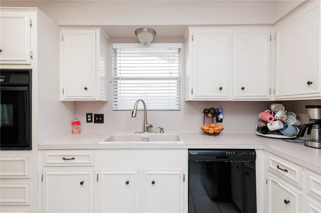 a kitchen with white cabinets and white appliances