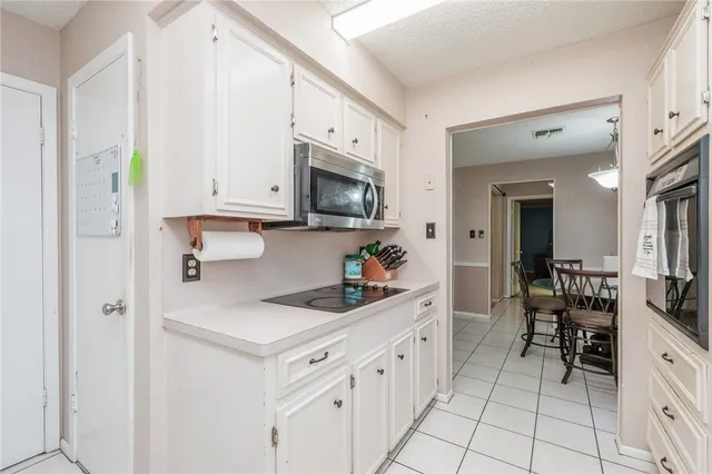 a kitchen with white cabinets and appliances