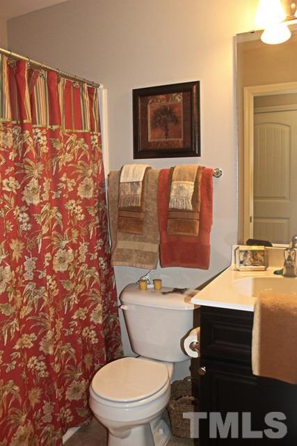 3972 Volkswalk Place Raleigh, NC 27610 - Photo 18 of 24 a bathroom with a toilet sink and mirror