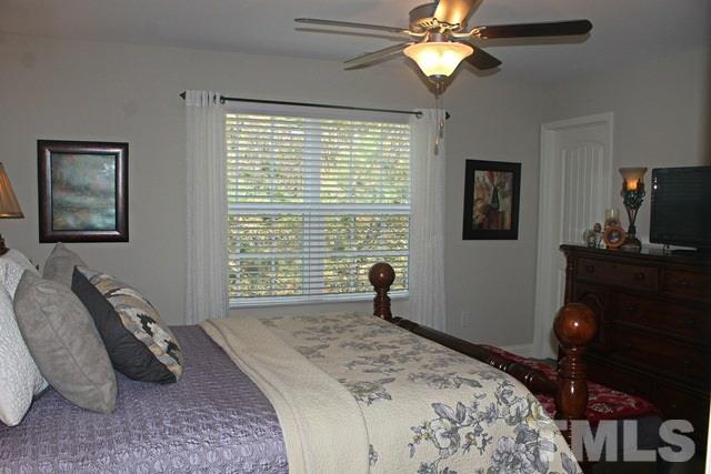 3972 Volkswalk Place Raleigh, NC 27610 - Photo 20 of 24 a bedroom with a bed and a chandelier
