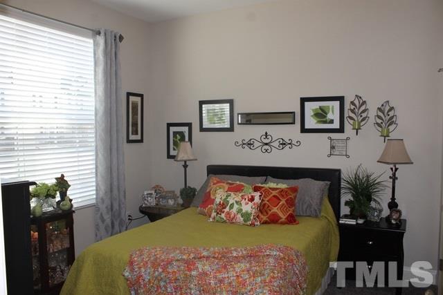 3972 Volkswalk Place Raleigh, NC 27610 - Photo 4 of 24 a bed sitting in a bedroom next to a window with a flower pot