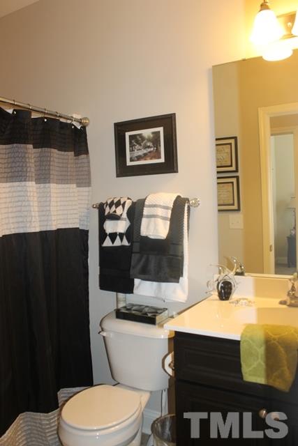 3972 Volkswalk Place Raleigh, NC 27610 - Photo 5 of 24 a bathroom with a sink a toilet and mirror