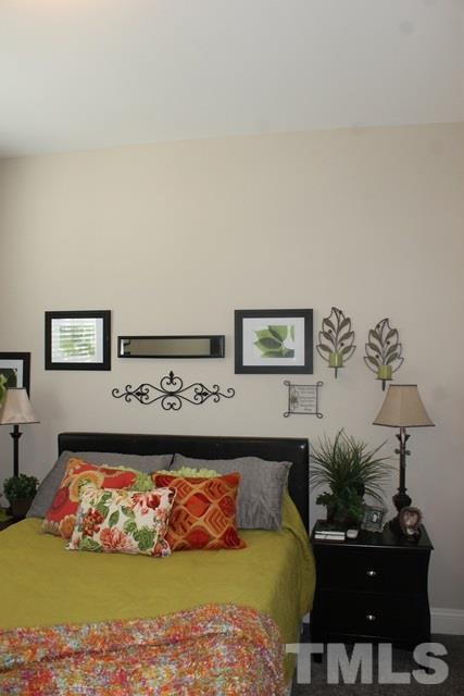 3972 Volkswalk Place Raleigh, NC 27610 - Photo 7 of 24 a bed room with furniture and painting on the wall