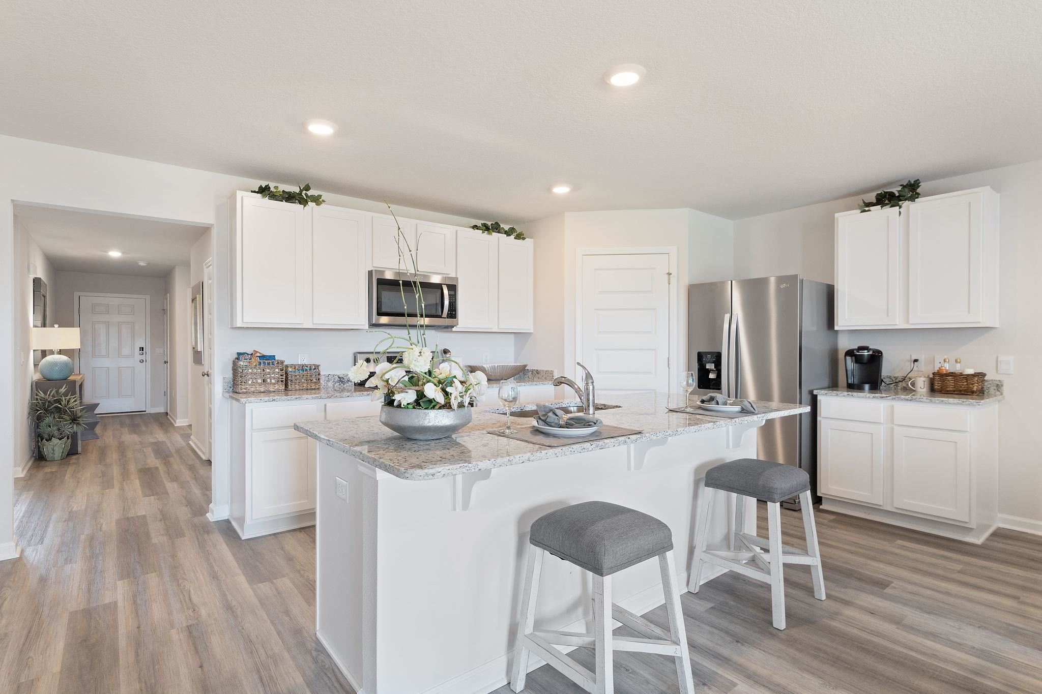 7505 Saddlebrook Avenue Pace, FL 32571 - Photo 9 of 16 a kitchen with sink a refrigerator and white cabinets