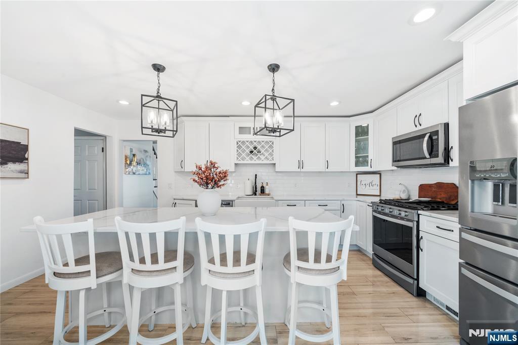 25 Glenview Road Nutley, NJ 07110 - Photo 11 of 49 a kitchen with stainless steel appliances granite countertop a kitchen island and chairs in it