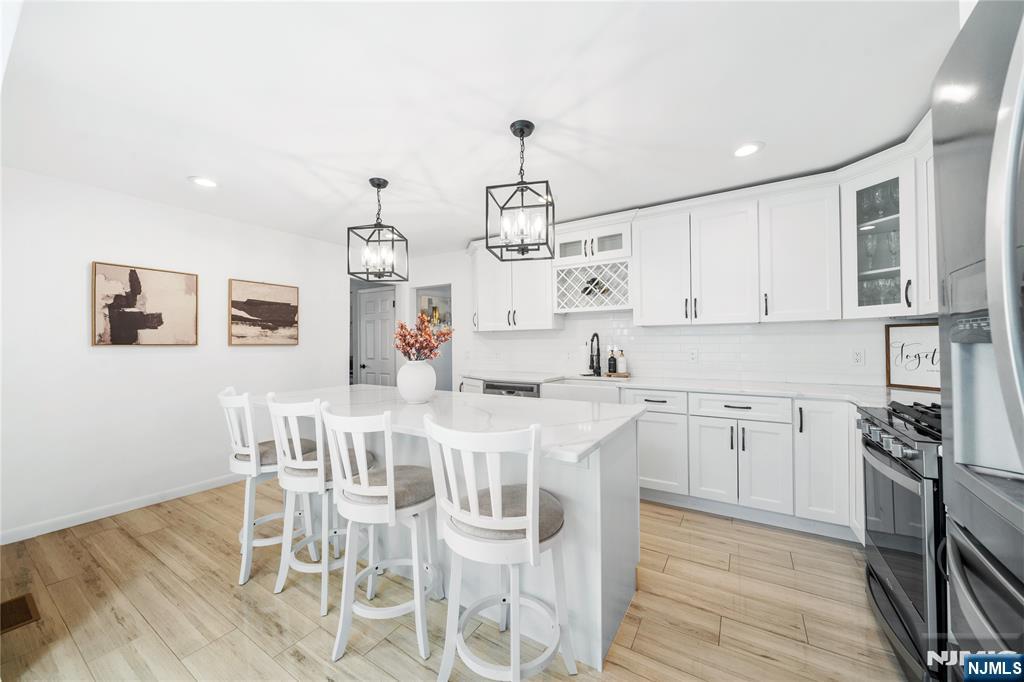 25 Glenview Road Nutley, NJ 07110 - Photo 12 of 49 a kitchen with stainless steel appliances kitchen island granite countertop a wooden floor and white cabinets