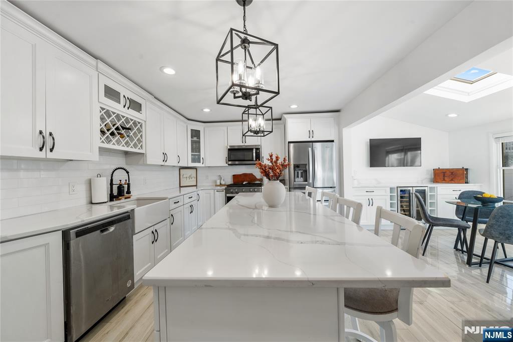 25 Glenview Road Nutley, NJ 07110 - Photo 14 of 49 a view of kitchen island a dining table wooden floor and stainless steel appliances