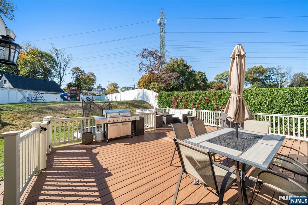 25 Glenview Road Nutley, NJ 07110 - Photo 49 of 49 a view of a patio with dining table and chairs with wooden floor and fence