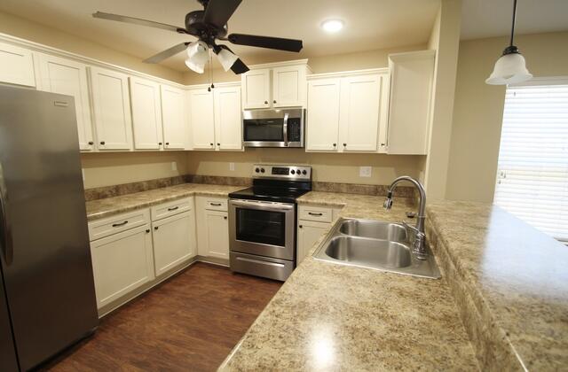 220 Wainwright Drive Crestview, FL 32539 - Photo 5 of 25 a kitchen with stainless steel appliances granite countertop a stove a sink and a refrigerator