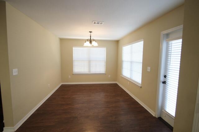220 Wainwright Drive Crestview, FL 32539 - Photo 6 of 25 an empty room with wooden floor chandelier and windows