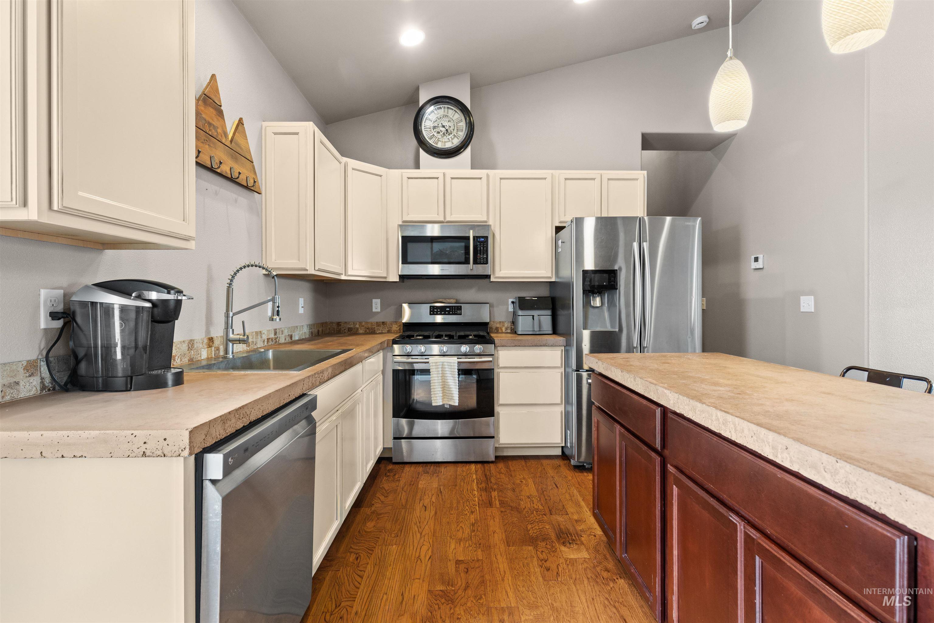 3810 21st Street Lewiston, ID 83501 - Photo 12 of 39 Kitchen with stainless steel appliances, light countertops, lofted ceiling, dark wood-type flooring, and pendant lighting