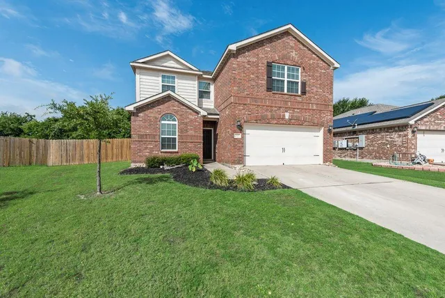 a front view of a house with a yard and garage