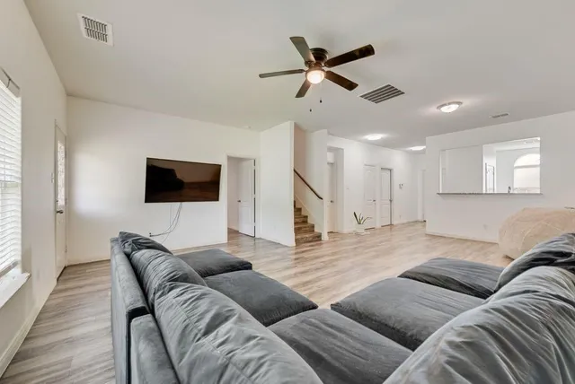 a living room with furniture and a flat screen tv with wooden floor