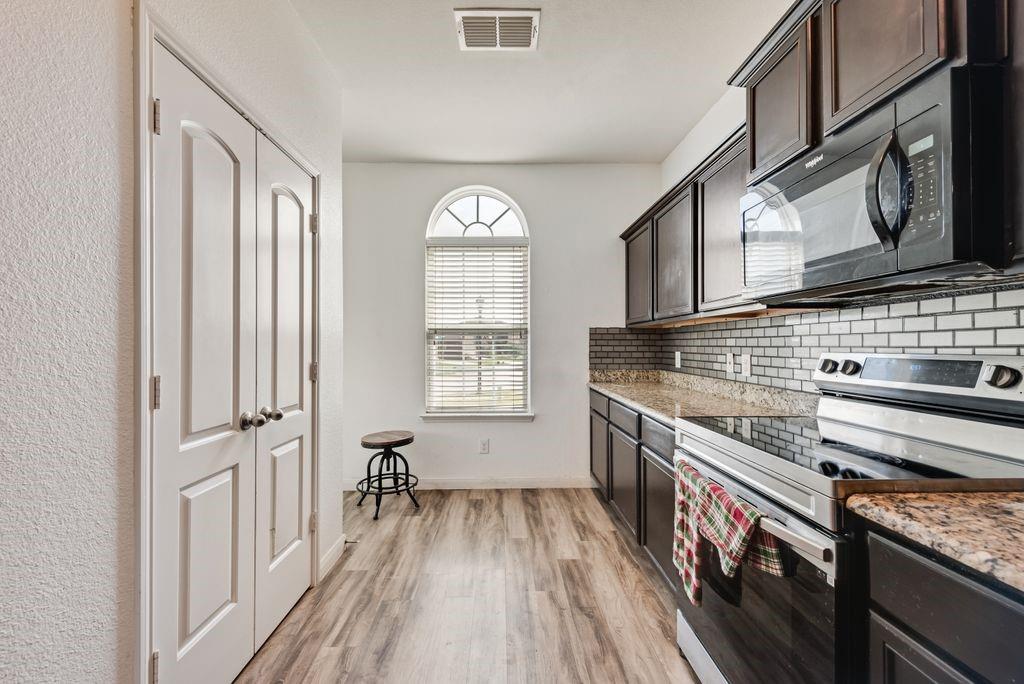 2907 Kyle Street Anna, TX 75409 - Photo 8 of 25 a kitchen with stainless steel appliances granite countertop a stove and a sink