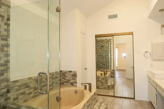 a bathroom with a tub sink and mirror