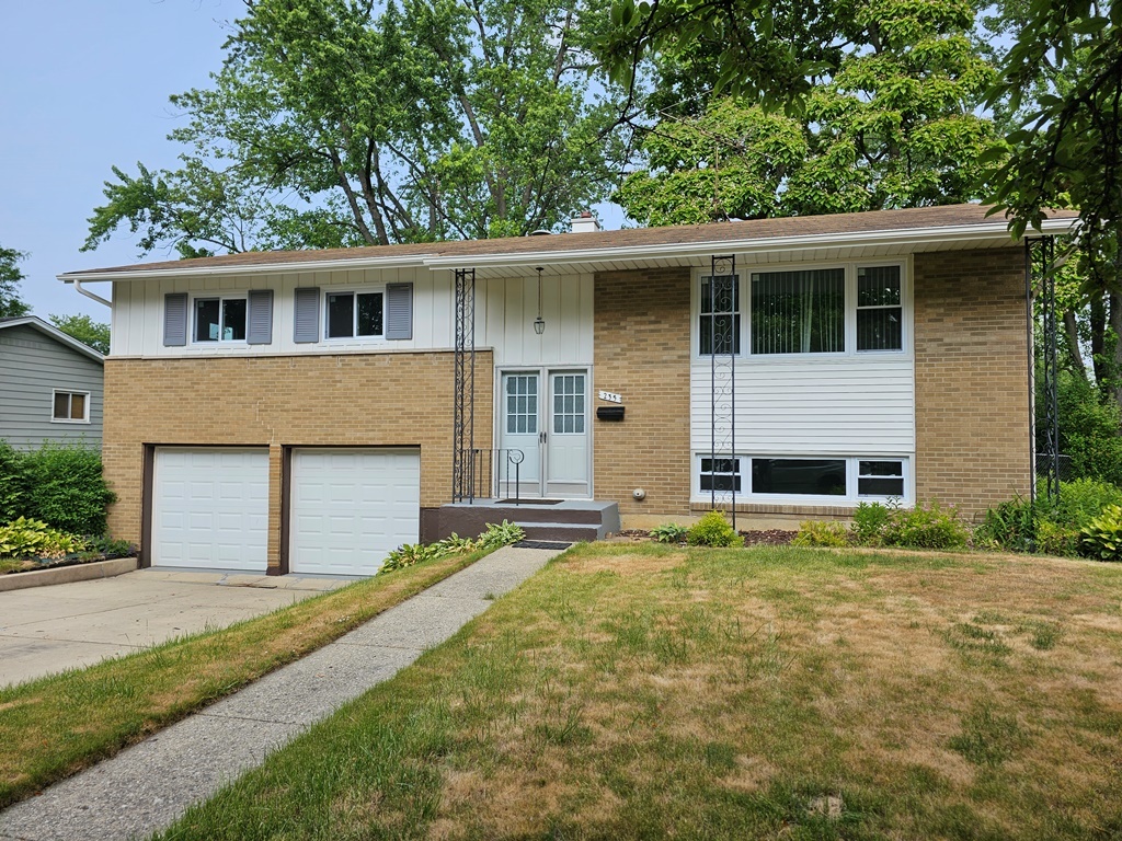 a front view of a house with a garden and garage