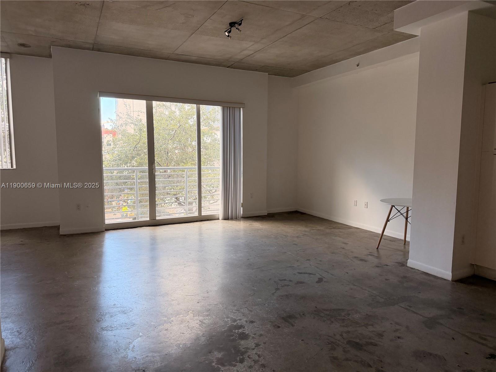 133 Northeast 2nd Avenue, Unit 209 Miami, FL 33132 - Photo 12 of 20 a view of an empty room with a window and wooden floor