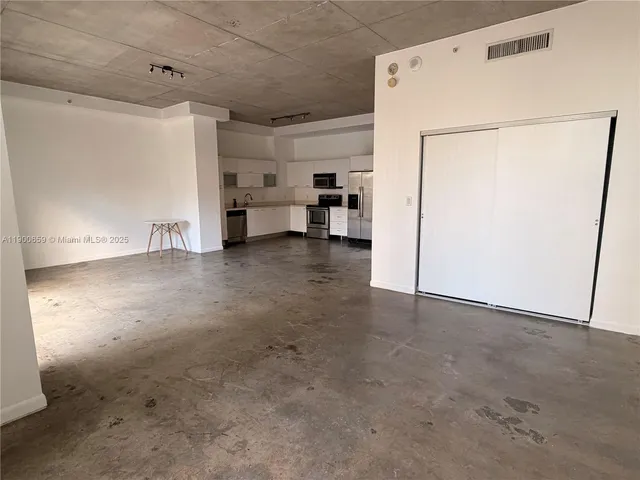 a view of kitchen with refrigerator and white cabinet