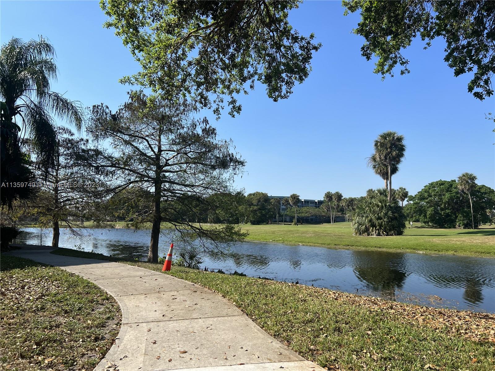 4361 West McNab Road, Unit 21 Pompano Beach, FL 33069 - Photo 12 of 18 a view of a lake with a yard