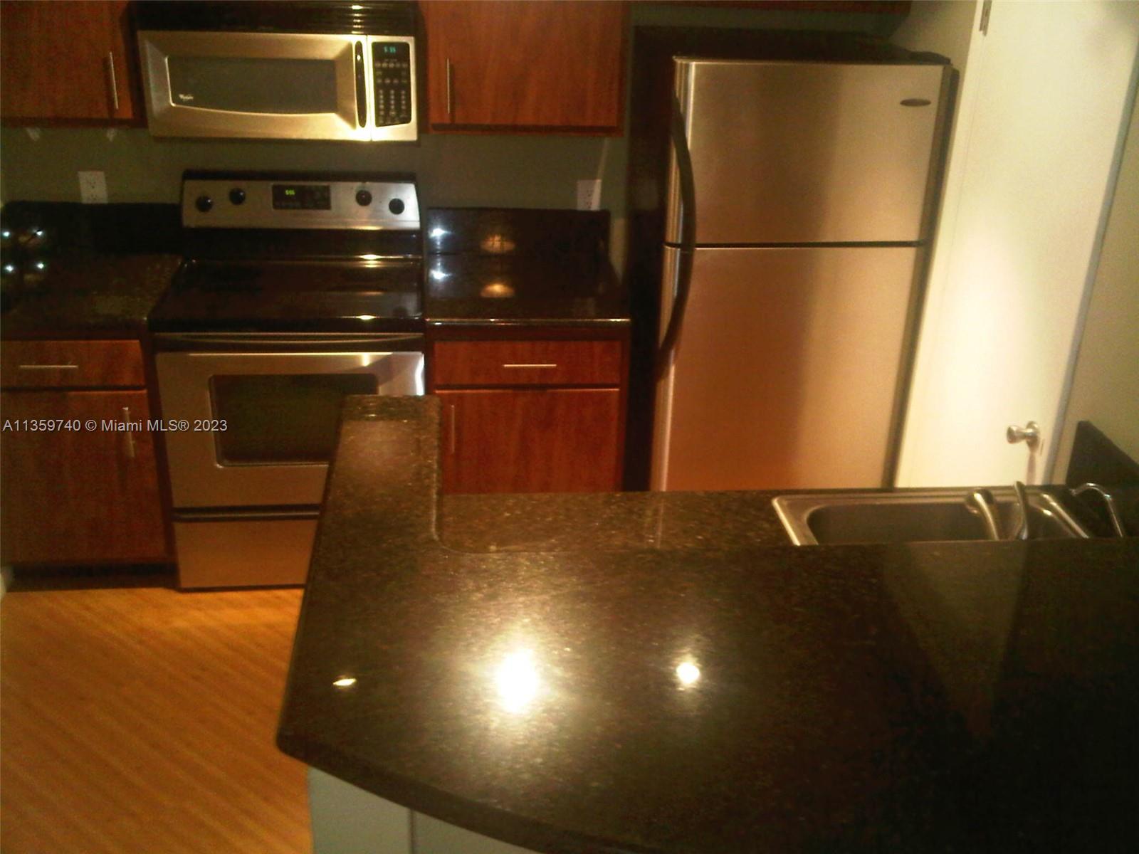 4361 West McNab Road, Unit 21 Pompano Beach, FL 33069 - Photo 6 of 18 a kitchen with a sink and a refrigerator